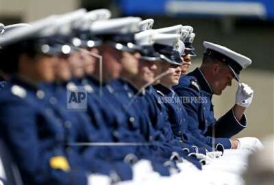A graduating Air Force Academy cadet straightens his cap during the graduation ceremony for the class of 2015, at the U.S. Air Force Academy, in Colorado Springs, Colo., Thursday, May 28, 2015. (AP Photo/Brennan Linsley)