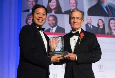 Deputy Labor Secretary Chris Lu holds the 2015 Management Excellence Award with winner Edward Hugler, the deputy assistant secretary for administration and management. Hugler is known as 