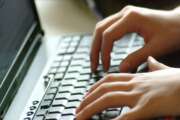 Hands typing on laptop keyboard.