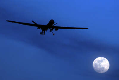 FILE - In this Jan. 31, 2010 file photo, an unmanned U.S. Predator drone flies over Kandahar Air Field, southern Afghanistan, on a moon-lit night.  Putting the U.S. military in charge of drone strikes in Iraq and Syria is leading to reduced congressional scrutiny.   Some officials and activists fear that means a greater risk of civilian casualties.   (AP Photo/Kirsty Wigglesworth, File)