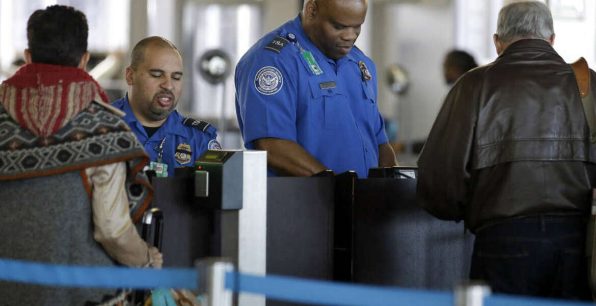 FILE - In this Nov. 25, 2015 file photo, Transportation Security Administration agents check travelers identifications at a security check point area in Terminal 3 at O'Hare International Airport in Chicago. Fliers who don't have the latest driver's licenses will have a two-year reprieve before their IDs are rejected at airport security checkpoints. Many travelers had been worried that the Transportation Security Administration would penalize them because of a federal law requiring the more-stringent IDs at the start of this year. (AP Photo/Nam Y. Huh, File)