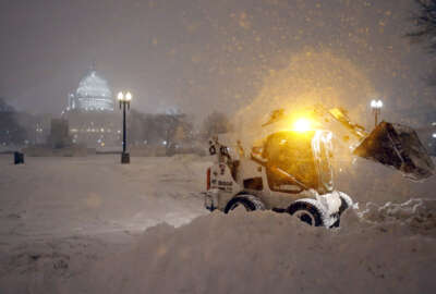 A bobcat piles up snow in front of the U.S. Capitol, as the snow continues to fall, Friday, Jan. 22, 2016, in Washington. (AP Photo/Alex Brandon)