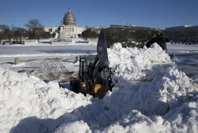 Snow is piled in front of the U.S. Capitol Building in Washington, Sunday, Jan. 24, 2016. Washington is digging out after a mammoth blizzard with hurricane-force winds and record-setting snowfall brought much of the East Coast to an icy standstill. (AP Photo/Carolyn Kaster)
