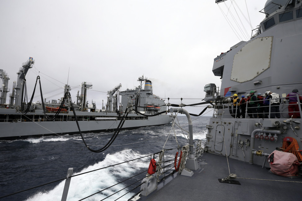 Fuel lines connect the USS William P. Lawrence guided missile destroyer, right, with a tanker during a refueling at sea Wednesday, Jan. 20, 2016, in waters off  Coronado, Calif. The U.S. Navy is launching a carrier strike group to be powered partly by biofuel, calling it a milestone toward easing the military's reliance on foreign oil. (AP Photo/Gregory Bull)