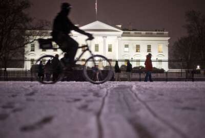 A bicyclist rides past the White House during evening snowfall in Washington,Wednesday, Jan. 20, 2016. As Washington prepares for this weekend's snowstorm, now forecast to reach blizzard conditions, a small clipper system pushed through the region Wednesday night causing massive delays and issues on the roads.(AP Photo/Pablo Martinez Monsivais)