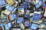 Mobile phones background. Pile of different modern smartphones.