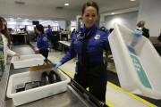 A TSA agent goes through items at a security checkpoint at Miami International Airport Tuesday, Nov. 24, 2015, in Miami. The big Thanksgiving getaway went into full swing Wednesday with drivers delighted by the lowest November gas prices in years and many airline passengers undaunted by terrorism fears and long lines at security checkpoints. (AP Photo/Lynne Sladky)