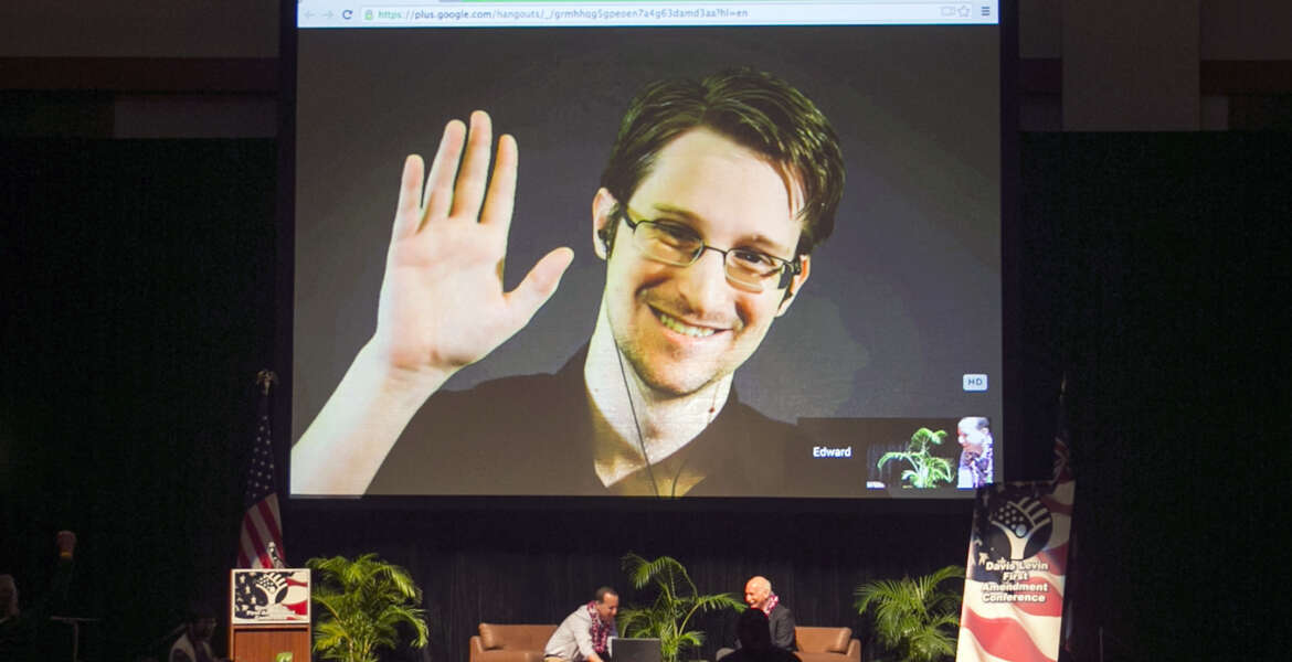 FILE - In this Feb. 14, 2015, file photo, Edward Snowden appears on a live video feed broadcast from Moscow at an event sponsored by ACLU Hawaii in Honolulu. Speaking via Skype from Russia, Snowden told an audience of supporters in New Hampshire on Saturday, Feb. 20, 2016, that he is willing to be extradited to the United States if the federal government would guarantee he would get a fair trial. The former National Security Agency contractor in 2013 leaked details of a secret government eavesdropping program and left the country. He faces U.S. charges that could land him in prison for up to 30 years. (AP Photo/Marco Garcia, File)