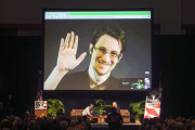 FILE - In this Feb. 14, 2015, file photo, Edward Snowden appears on a live video feed broadcast from Moscow at an event sponsored by ACLU Hawaii in Honolulu. Speaking via Skype from Russia, Snowden told an audience of supporters in New Hampshire on Saturday, Feb. 20, 2016, that he is willing to be extradited to the United States if the federal government would guarantee he would get a fair trial. The former National Security Agency contractor in 2013 leaked details of a secret government eavesdropping program and left the country. He faces U.S. charges that could land him in prison for up to 30 years. (AP Photo/Marco Garcia, File)