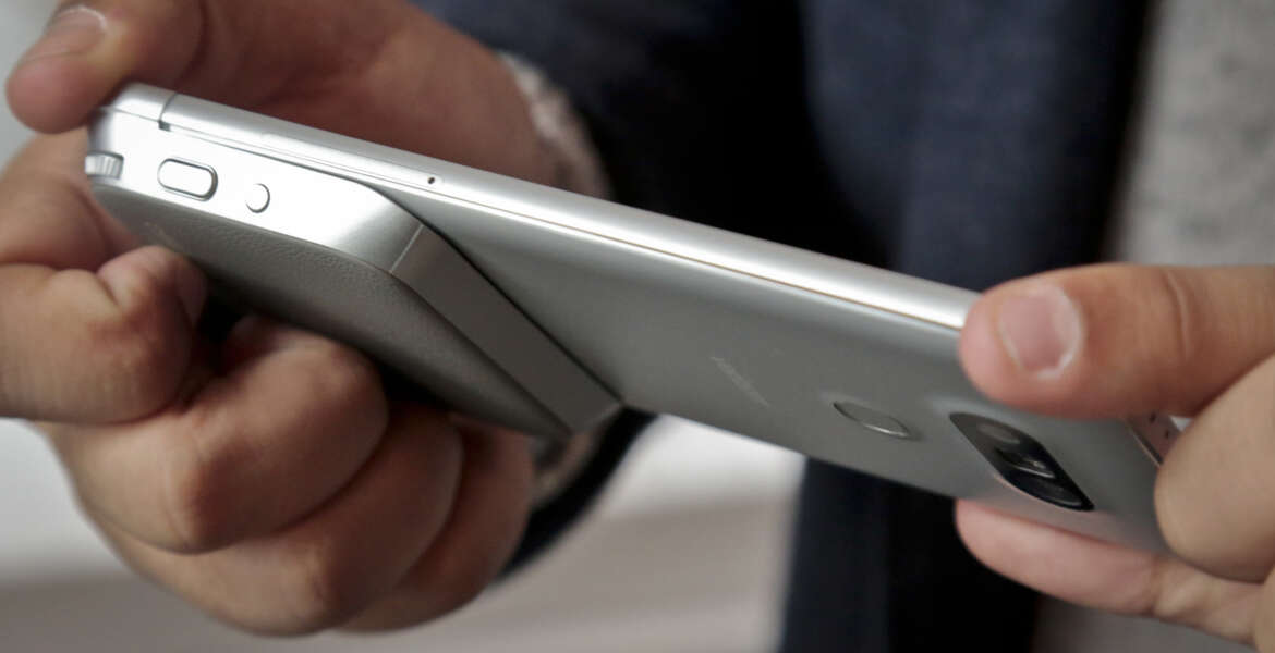 This Feb. 11, 2016, photo, shows a camera grip, at bottom left, with physical buttons to take the photos and record video with the LG G5 phone, in New York. The grip connects to the phone's bottom. LG is dipping its toes into a modular-design concept with its upcoming G5 smartphone. (AP Photo/Bebeto Matthews)