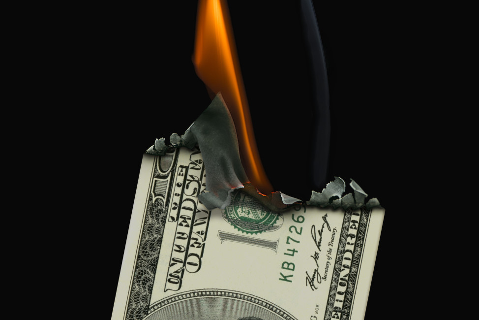 100 Dollar Banknote on fire set on a black background.