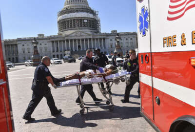 EDS NOTE: The suspect's face was digitally altered by the Washington Post at the request of the Washington D.C. Fire and EMS Department. First responders transport the person believed to be the suspect in a shooting at the U.S. Capitol complex Monday, March 28, 2016, in Washington. Visitors and staff were shut in their offices and told to 