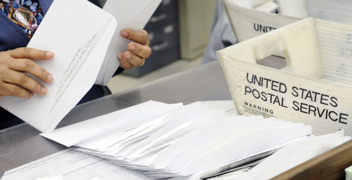 In this Feb. 5, 2016, photo, a mail clerk at the Wynne Unit of the Texas prison system makes her way through a box of letters for inmates in Huntsville, Texas. Every piece of mail is checked for contraband, like drugs hidden under stamps, or messages or words in correspondence that suggest violence or escape plans, as well as attempts by convicts to profit from some enterprise or business while behind bars. (AP Photo/Pat Sullivan)
