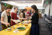 Dressed in period clothes, staff members of the Smithsonian Institution's National Museum of American History try food from a 1950s potluck lunch.