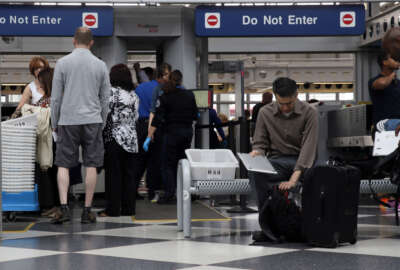Travelers pass through a Transportation Security Administration checkpoint at O'Hare International Airport, Friday, May 27, 2016, in Chicago. Memorial Day weekend, the unofficial start of summer vacations for many and a busy travel period, serves as a crucial test for the TSA. (AP Photo/Kiichiro Sato)