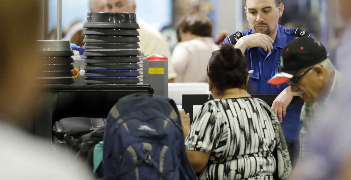 A Transportation Security Administration officer watches as passengers put their luggage through an X-ray machine at a TSA checkpoint at Miami International Airport, Thursday, May 26, 2016, in Miami. Memorial Day weekend, the unofficial start of summer vacations for many and a busy travel period, serves as a crucial test for the agency. (AP Photo/Alan Diaz)