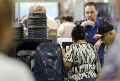 A Transportation Security Administration officer watches as passengers put their luggage through an X-ray machine at a TSA checkpoint at Miami International Airport, Thursday, May 26, 2016, in Miami. Memorial Day weekend, the unofficial start of summer vacations for many and a busy travel period, serves as a crucial test for the agency. (AP Photo/Alan Diaz)