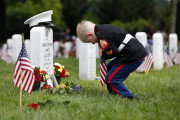 Christian Jacobs, 5, of Hertford, N.C., dressed as a Marine, works to place a flag in front of his father's gravestone on Memorial Day in Section 60 at Arlington National Cemetery in Arlington, Va., Monday, May 30, 2016. Christian's father Marine Sgt. Christopher James Jacobs died in a training accident in 2011. (AP Photo/Carolyn Kaster)