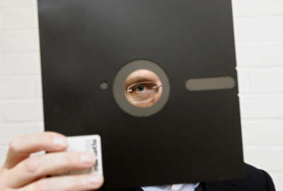 FILE - In this Nov. 16, 2004 file photo, an obsolete 8 and 1-half inch floppy disc  is held in London. Congressional investigators say the government spends about three-fourths of its technology budget maintaining aging computer systems. That includes platforms more than 50 years old in such vital areas as nuclear weapons and Social Security. One still uses floppy disks. (AP Photo/Adam Butler, File)