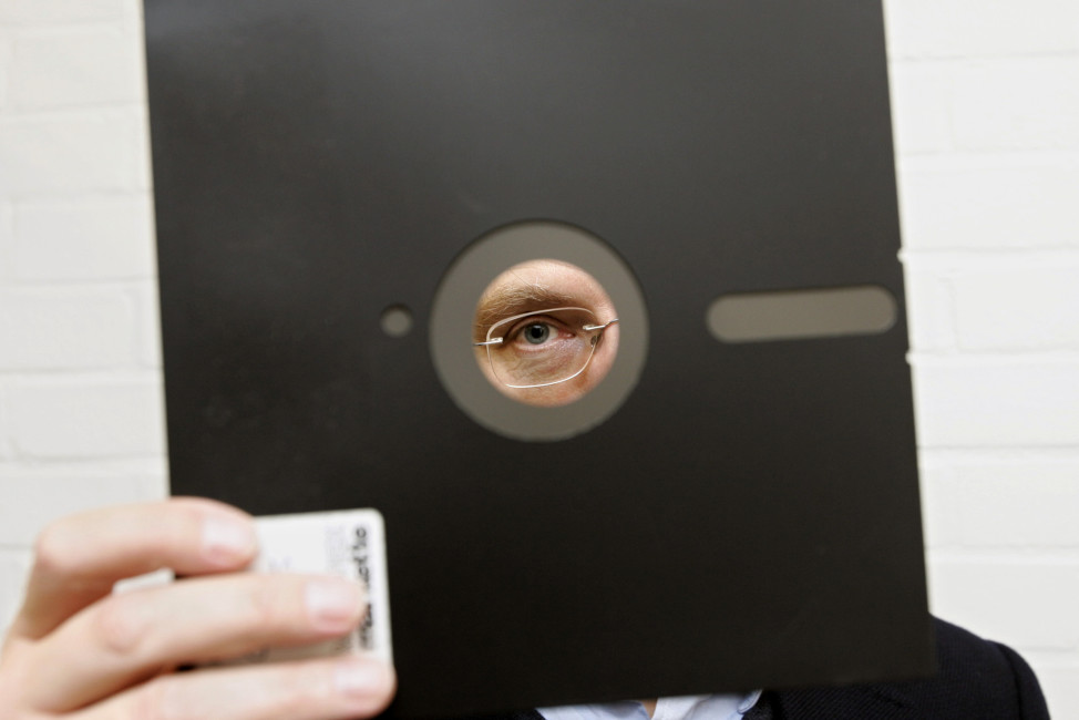 FILE - In this Nov. 16, 2004 file photo, an obsolete 8 and 1-half inch floppy disc  is held in London. Congressional investigators say the government spends about three-fourths of its technology budget maintaining aging computer systems. That includes platforms more than 50 years old in such vital areas as nuclear weapons and Social Security. One still uses floppy disks. (AP Photo/Adam Butler, File)