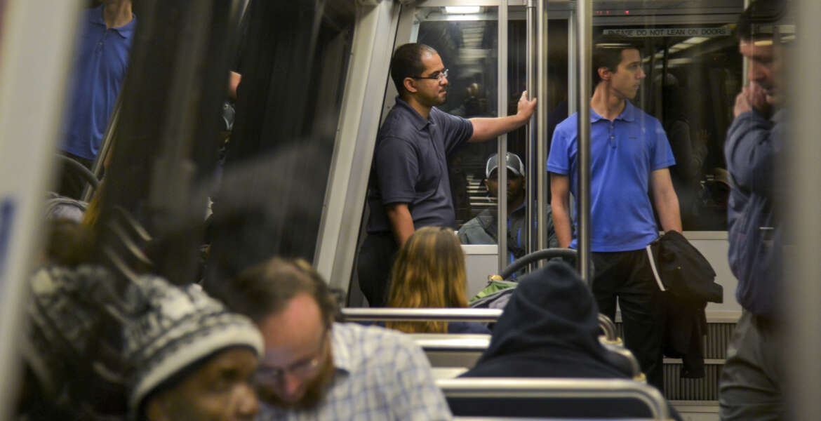In this Thursday, April 28, 2016 photo, Roger Bowles, center, and Stephen Repetski, center right, ride a blue line Metro train from the McPherson Square Station to Crystal City in Washington. The two are part of a group of hobbyists who monitor the rails for any anomalies or abnormalities and provide real-time info of problems. (Jahi Chikwendiu/The Washington Post via AP) MANDATORY CREDIT