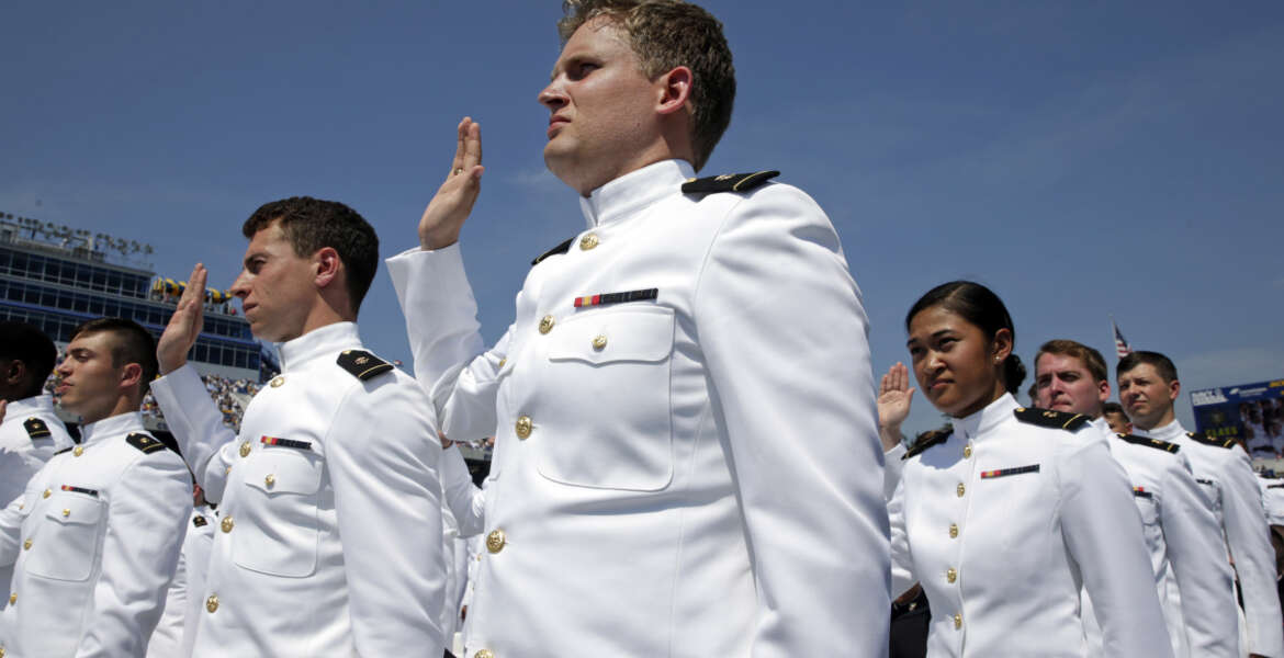 Graduating U.S. Naval Academy Midshipmen raise their right hands as they are commissioned as ensigns in the U.S. Navy during the Academy's graduation and commissioning ceremony in Annapolis, Md., Friday, May 27, 2016. (AP Photo/Patrick Semansky)