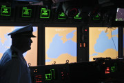 FILE- In this Tuesday, June 7, 2011 file photo, a US Navy officer, name not available, stands on the weapons control deck of the USS Monterey as screens display the Black Sea region, in the Black Sea port of Constanta, Romania. A U.S. missile defense system aimed at protecting Europe from ballistic missile threats is moving into higher gear this week, with a site in the village of Deveselu, Romania becoming operational on Thursday, May 12, 2016, and officials breaking ground at a separate site in Poland a day later.(AP Photo/Vadim Ghirda, File)