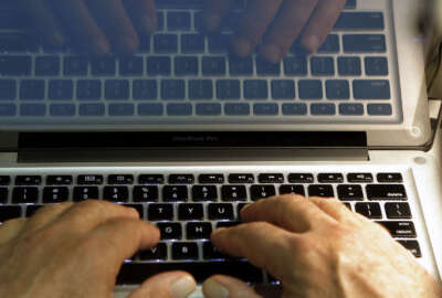 FILE - In this Feb. 27, 2013, file photo, hands type on a computer keyboard in Los Angeles. News that Facebook founder Mark Zuckerberg's rarely used Twitter, LinkedIn and Pinterest accounts were briefly compromised should serve as a reminder that we’re all susceptible to hacking. (AP Photo/Damian Dovarganes, File)