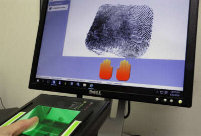 A technician at FIRM Systems demonstrates how finger prints are scanned and captured using Livescan biometric fingerprint technology Monday, June 6, 2016, in Springfield, Ill. Among those that the deadbeat state owes money is the Federal Bureau of Investigation. Because of the state's budget troubles, the Illinois State Police owes the FBI $3 million for processing fingerprints as part of non-criminal background checks. The agency says it won't stop the services, but it's the latest security issue to emerge from the budget mess. (AP Photo/Seth Perlman)