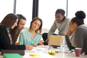 Diverse group of young students working together on school assignments. Multiethnic people studying together at a table.