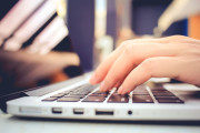 Female hands typing on keyboard of laptop