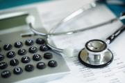 Calculator and stethoscope on financial statement concept for finance health check or cost of healthcare