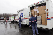 In this Thursday, Dec. 17, 2015 photo, U.S. Postal workers show off trucks of Christmas cards and packages to be delivered to Saryre Terry in Rotterdam, N.Y. Terry, who lost her father and siblings in an arson fire that left her severely scarred is sharing the good cheer bestowed on her by the truckload since her simple Christmas wish went viral. (AP Photo/Mike Groll)