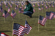 Navy veteran Jeff Hensley of Dallas, Texas, now with Iraq and Afghanistan Veterans of America (IAVA), joins others in placing 1,892 flags representing veteran and service members who have died by suicide to date in 2014, Thursday, March 27, 2014, on the National Mall in Washington. The event also marked the introduction of The Suicide Prevention for America's Veterans Act by Sen. John Walsh, D-Mont., which calls for greater access to mental health care. (AP Photo/Charles Dharapak)