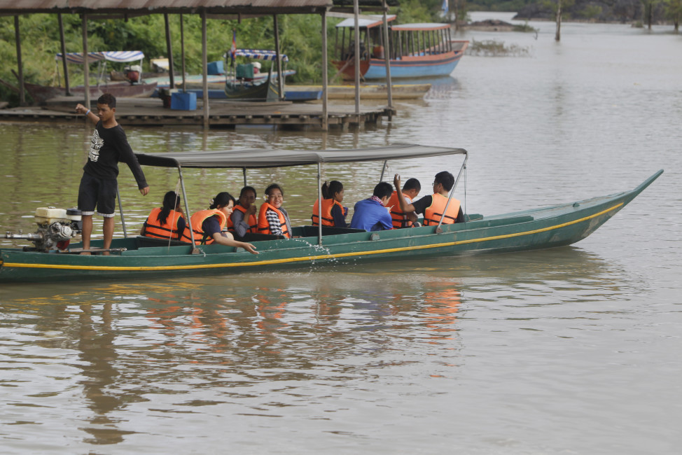 In this June 21, 2016, photo, tourists sit on a wooden boat as they start to cross the Mekong River to close a habitat of dolphin, which is located near the site of Don Sahong dam, near Cambodia-Laos borders, in Preah Romkel village, Stung Treng province, northeast of Phnom Penh, Cambodia. Landlocked Laos is the poorest state in Southeast Asia but by virtue of geography and growing Chinese influence, its secretive authoritarian leaders wield a huge and unaccountable power over a river that winds through six countries. (AP Photo/Heng Sinith)