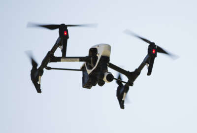 FILE - In this April 14, 2016 file photo, a drone captures videos and still images of an apartment building in Philadelphia. Federal aviation officials say so many people are registering drones and applying for drone pilot licenses, they wonder if there will eventually be millions of drones crowding the nation's skies.  (AP Photo/Matt Rourke, File)