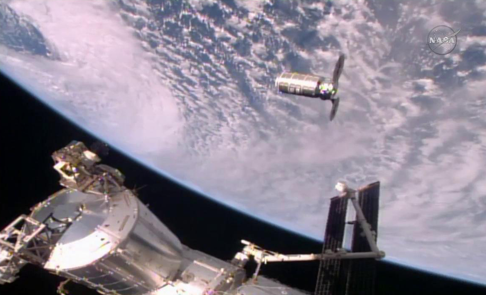 This photo provided by NASA TV shows the Cygnus resupply ship, above, slowly approaching the International Space Station before the Canadarm2 reaches out and grapples it, Sunday, Oct. 23, 2016. Once the Cygnus is unloaded, it will be filled with trash and set loose to burn up in the atmosphere in mid-November. (NASA TV via AP)