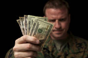 A military man looks angry as he hands over money