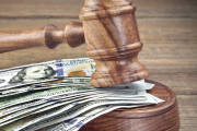 Judges or Auctioneers Gavel Or Hammer And Big Money Stack On Wooden Bench Or Wooden Table Background, Concept For Financial Crime, Close Up