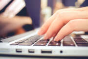 Female hands typing on keyboard of laptop