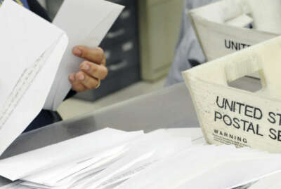 In this Feb. 5, 2016, photo, a mail clerk at the Wynne Unit of the Texas prison system makes her way through a box of letters for inmates in Huntsville, Texas. Every piece of mail is checked for contraband, like drugs hidden under stamps, or messages or words in correspondence that suggest violence or escape plans, as well as attempts by convicts to profit from some enterprise or business while behind bars. (AP Photo/Pat Sullivan)