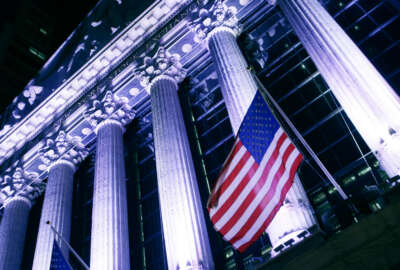 FILE - In this Wednesday, Oct. 8, 2014, file photo, an American flag flies in front of the New York Stock Exchange. U.S. stocks are mixed early Wednesday, Dec. 7, 2016, as large drugmakers take losses and most other industries move slightly higher. Bond yields are falling, and investors are buying stocks that pay large dividends. That's leading to gains for real estate investment trusts, utilities and phone companies. (AP Photo/Mark Lennihan, File)
