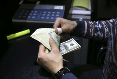 In this picture taken on Monday, Dec. 26, 2016, a currency exchange bureau owner counts U.S. dollars in downtown Tehran, Iran. Iran’s currency has struck an all-time low this week, trading at 41,600 rials to $1. While making Iranian exports more attractive to the world market in the wake of the nuclear deal, it also means people’s savings continue to lose value in the Islamic Republic. Meanwhile, concerns gather about what U.S. President-elect Donald Trump might mean for the atomic accord going forward, even as most Iranians have yet to feel any change from it.(AP Photo/Vahid Salemi)