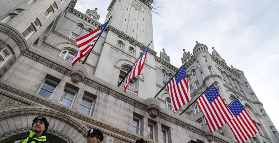 In this Jan. 19, 2017, photo, police stand guard outside the Trump International Hotel on Pennsylvania Avenue in Washington. While President Donald Trump’s hotel in Washington did serve as a hub of inaugural activities it also stands as ground zero for what top Democrats and some ethics advisers see as his unique web of conflicts of interest. Trump’s lease with the federal government to develop and operate a hotel inside the historic Old Post Office building expressly prohibits any elected official from benefiting from the property, yet Trump has not divested from his company or this particular project. (AP Photo/John Minchillo)