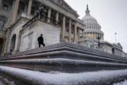 A police officer stands at his post on the steps of the House of Representatives on Capitol Hill in Washington, Tuesday morning, March, 14, 2017, following an overnight snowfall. A late-season storm is dumping a messy mix of snow, sleet and rain on the mid-Atlantic, complicating travel, knocking out power and closing schools and government offices around the region.  (AP Photo/J. Scott Applewhite)