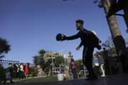 Michigan's Nick Eubanks throws a football with a young Italian boy after a day at Ninfe Beach on Lake Albano, about 16 miles southeast of Rome, Tuesday, April 25, 2017. Michigan's NCAA college football team arrived in Rome last weekend and kicked off the unique trip by meeting with refugees before going to the Vatican for a Papal address before practicing a few times. (Romain Blanquart/Detroit Free Press via AP)