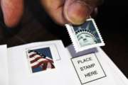 FILE - In this Dec. 5, 2011 file photo, a customer places first class stamps on envelopes at a U.S. Post Office in San Jose, Calif. The U.S. Postal Service is hoping it can soon raise stamp prices by a penny or more.  (AP Photo/Paul Sakuma, File)