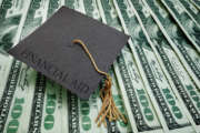 graduation cap with Financial Aid text on assorted hundred dollar bills