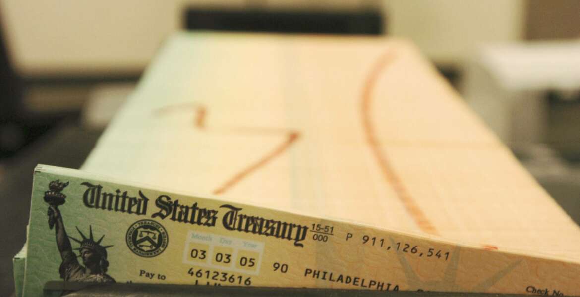 FILE - In this Feb. 11, 2005, file photo, trays of printed social security checks wait to be mailed from the U.S. Treasury's Financial Management services facility in Philadelphia. The AP reported on June 30, 2017, that a story being shared online crediting President Donald Trump for a routine cost of living adjustment for Social Security recipients is false. (AP Photo/Bradley C. Bower, File)