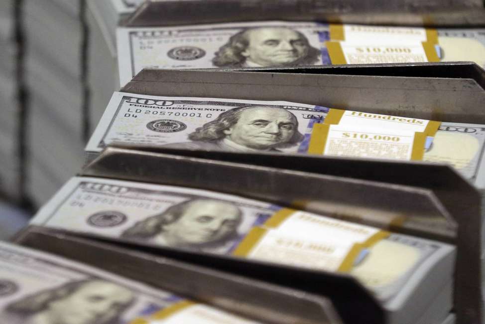 FILE - In this Sept. 24, 2013, file photo, freshly cut stacks of $100 bills make their way down the line at the Bureau of Engraving and Printing Western Currency Facility in Fort Worth, Texas. Workers are setting aside more of their paychecks in their 401(k), and lower-income workers are much more likely to be saving than years ago, according to the latest data from Vanguard, released in June 2017.
 (AP Photo/LM Otero, File)